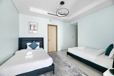 two beds in a room with white walls at StoneTree - Furnished 2 BR with City View in Dubai