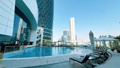 a pool in a building with chairs and an umbrella at DIFC Luxurious Spacious 1-Bed Apt in a Prime Location in Dubai