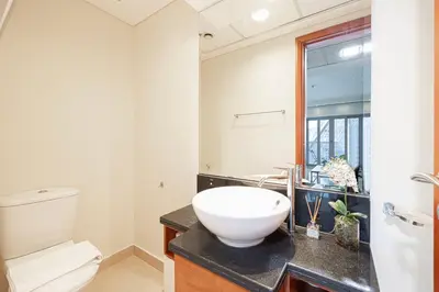 a bathroom with a white toilet and a sink at DIFC Luxurious Spacious 1-Bed Apt in a Prime Location in Dubai