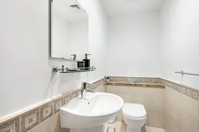 a white bathroom with a sink and a toilet at StoneTree - Luxurious 1 BR with Beach Access at Fairmont The Palm in Dubai