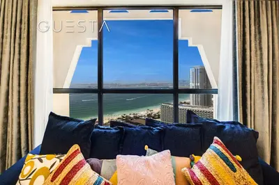 a couch with pillows in front of a large window at Jumeirah Beach Residence - Rimal 4, Dubai Marina in Dubai