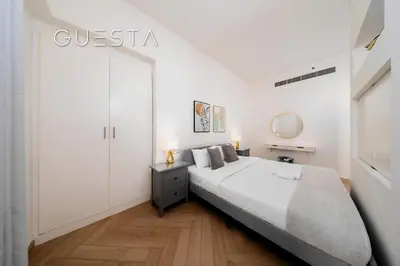 a white bedroom with a bed and a white wall at Jumeirah Beach Residence - Rimal 4, Dubai Marina in Dubai