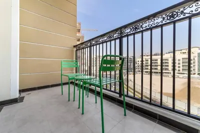 a couple of green chairs sitting on a balcony at StoneTree - Modern Style of Studio in Resortz by Danube in Dubai
