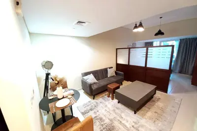 a living room with a couch and a table at StoneTree - Furnished Studio near Metro Station in Dubai