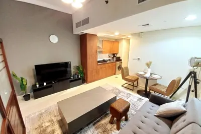 a living room with a couch and a table at StoneTree - Furnished Studio near Metro Station in Dubai