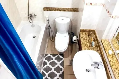 a bathroom with a toilet and a tub and a sink at StoneTree - Furnished Studio with Lake View and near Metro in Dubai