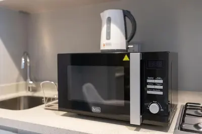 a microwave on a kitchen counter with a blender on top at Coastal Bay 1 Bedroom in Dubai