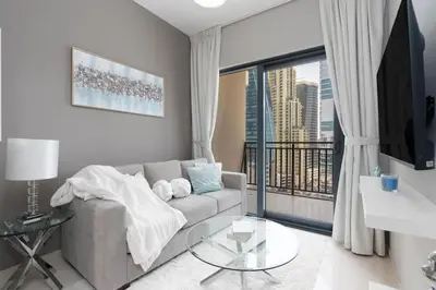a living room with a couch and a large window at Coastal Bay 1 Bedroom in Dubai