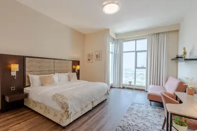 a bedroom with a large bed and a desk at BEAUTIFUL HUGE 2 BED ROOM APARTMENT in Dubai
