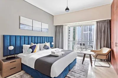 a bedroom with a large bed with a blue headboard at StoneTree - Stylish Studio near Metro Station in Dubai