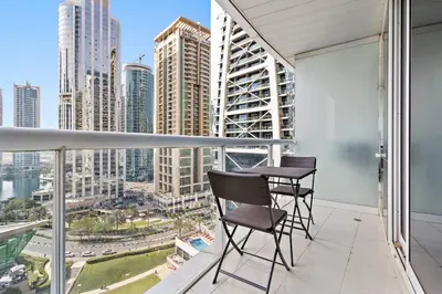a balcony with two chairs and a view of the city at StoneTree - Stylish Studio near Metro Station in Dubai