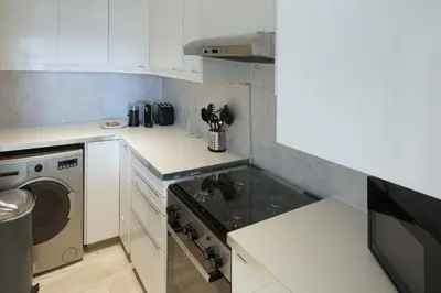 a small kitchen with a stove and a dishwasher at Plaza Residences - 2BR Apartment - Allsopp&Allsopp in Dubai