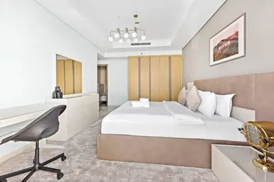 a bedroom with a bed and a desk and a sink at StoneTree - Luxurious 2 BR Apartment with Stunning View in Dubai