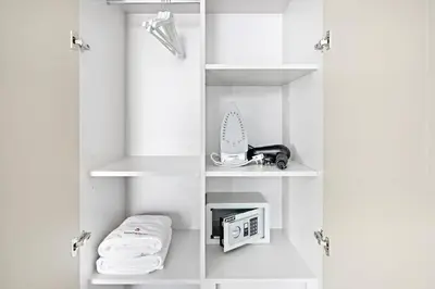 a white closet with white shelves and towels at StoneTree - Luxurious 2 BR Apartment with Stunning View in Dubai