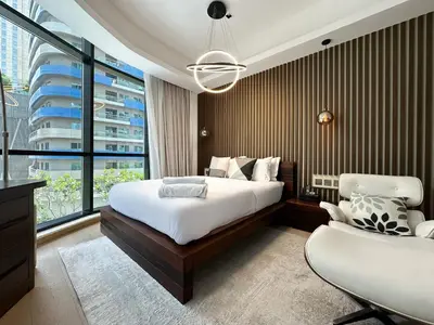 a bedroom with a bed and a large window at Trophy - Private Office Solace Suite in Dubai