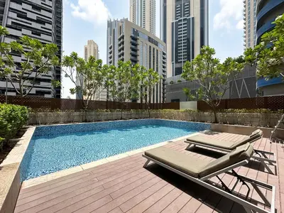 a swimming pool with a chaise lounge next to a city at Trophy - Private Office Solace Suite in Dubai