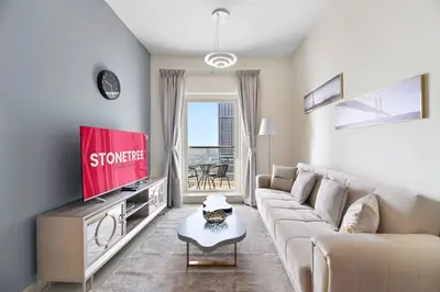 a living room with a couch and a flat screen tv at StoneTree - Elegant 1 BR with Amazing View in Dubai
