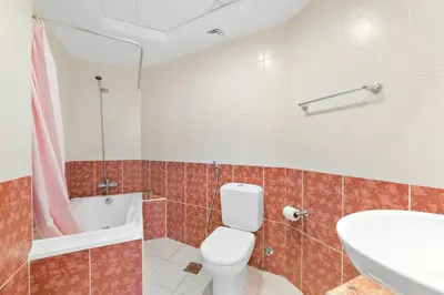 a bathroom with a toilet and a tub and a sink at StoneTree - Elegant 1 BR with Amazing View in Dubai