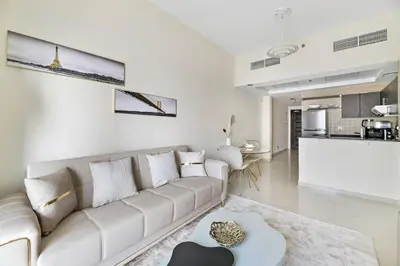 a white living room with a couch and a table at StoneTree - Elegant 1 BR with Amazing View in Dubai