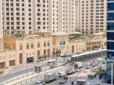 a busy city street with traffic in front of buildings at StoneTree - Furnished 1BR near Marina Walk in Dubai