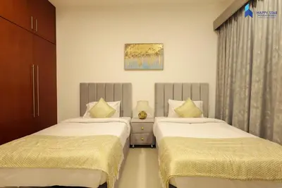two beds in a hotel room withskirts at Stylish 2BR Suite Near MOE in Dubai