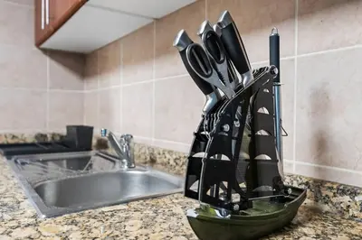 a bunch of knives in a holder next to a sink at StoneTree - Homelike 1BR in Dubai Marina in Dubai