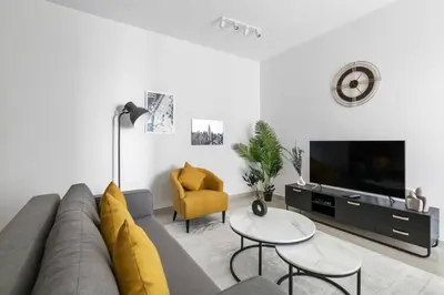 a living room with a couch and a tv at StoneTree - Homelike 1BR in Dubai Marina in Dubai