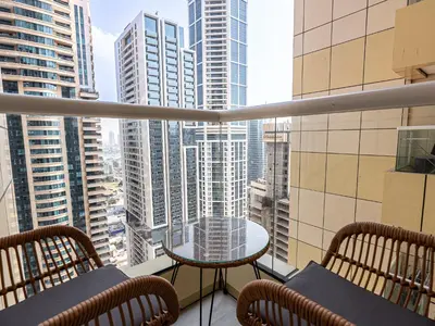 a balcony with a table and chairs and a view of a city at Daniels Spacious 1BR in Heart of Dubai Marina in Dubai
