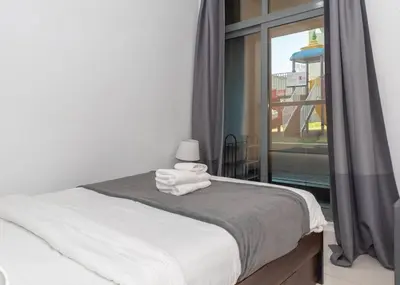 a bedroom with a bed and a large window at StoneTree - Cozy Studio Apartment in Business Bay in Dubai