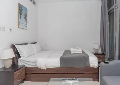 a bedroom with a bed and a desk and a couch at StoneTree - Cozy Studio Apartment in Business Bay in Dubai