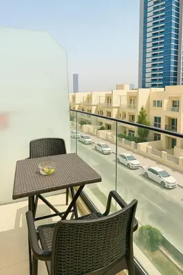 a table and chairs on a balcony with a view of a city at Stunning Studio in Dubai in Dubai