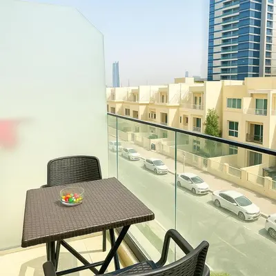 a table and chairs on a balcony with a view of a city at Stunning Studio in Dubai in Dubai