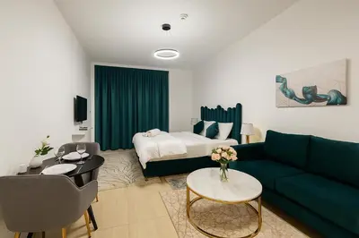 a living room with a green couch and a bed at Stunning Studio in Dubai in Dubai