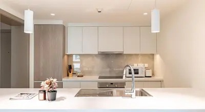 a kitchen with white cabinets and a sink at Classy 1 BR Apartment in Greens in Dubai