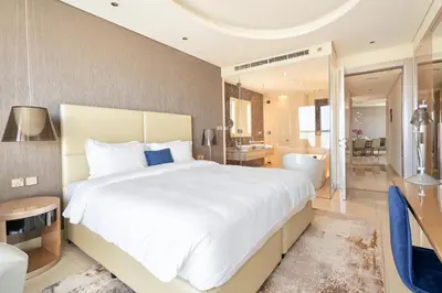 a bedroom with a large white bed and a bathroom at ALiving Supreme 3BR I Paramount Towers, Business Bay- 6104 in Dubai