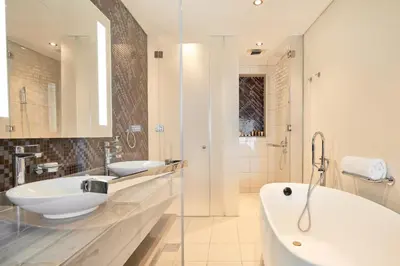 a white bathroom with two sinks and a tub at ALiving Supreme 3BR I Paramount Towers, Business Bay- 6104 in Dubai