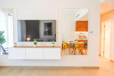 a kitchen with white cabinets and a table with yellow chairs at Yogi - Luxury Apartment With Sea View Close to the Beach in Dubai