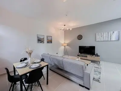 a living room with a couch and a table and chairs at StoneTree - Modern 1 BR Apartment Near The Beach in Dubai