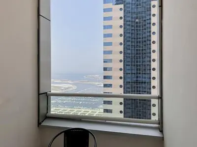 a view of a tall building from a window at StoneTree - Modern 1 BR Apartment Near The Beach in Dubai