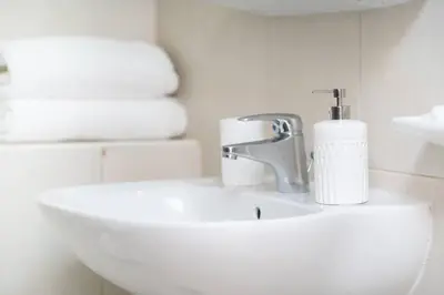a bathroom with a sink and a toilet with towels at StoneTree - Chic Studio in Jumeirah Lake Towers in Dubai
