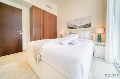 a bedroom with a white bed with two towels on it at Contemporary 1BR at Vera Tower Business Bay by Deluxe Holiday Homes in Dubai