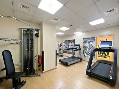 a gym with treadmills and machines in a room at StoneTree - Stylish 1BR near Marina Walk in Dubai
