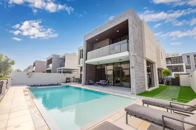a swimming pool in front of a building at Daniels 5BR Villa with Private Pool at Damac Hills in Dubai