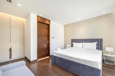 a bedroom with a large bed and a wooden door at Daniels 5BR Villa with Private Pool at Damac Hills in Dubai