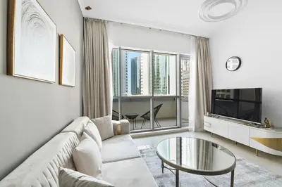 a living room with a couch and a glass table at StoneTree - Furnished 1 BR in Bay Central in Dubai