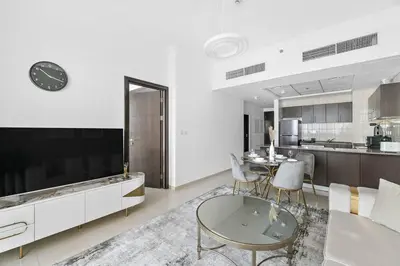 a living room with a large television and a table at StoneTree - Furnished 1 BR in Bay Central in Dubai