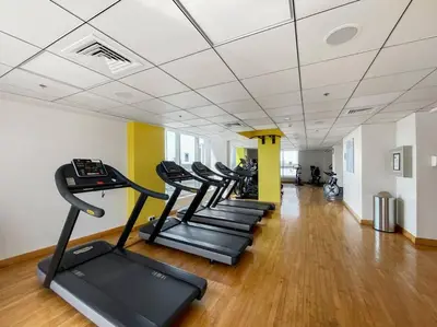 a row of treadmills in a gym with a row of treadms at StoneTree - Furnished 1 BR in Bay Central in Dubai