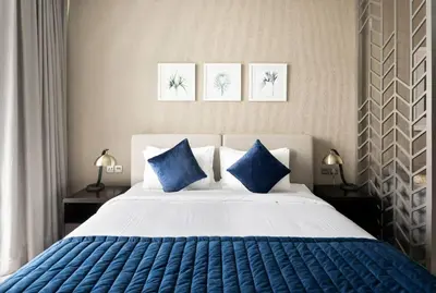 a bedroom with a large bed with blue pillows at Phineek Homes Luxury Studio With Canal View Damac Maison Prive Business Bay in Dubai