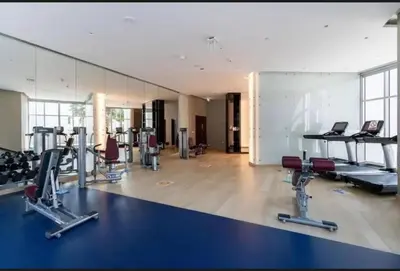 a gym with several treadmills and cardio machines at Phineek Homes Luxury Studio With Canal View Damac Maison Prive Business Bay in Dubai