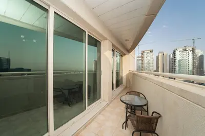 a balcony with two tables and chairs on a balcony at StoneTree - Fully Furnished 1BR near Metro Station in Dubai